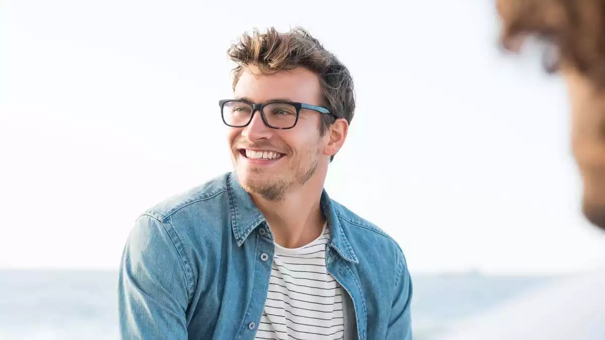 Man with glasses smiling.