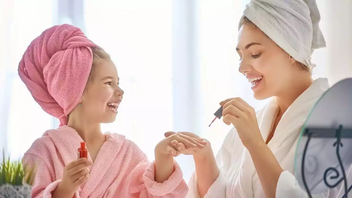 Mother and daughter after a shower doing their nails.