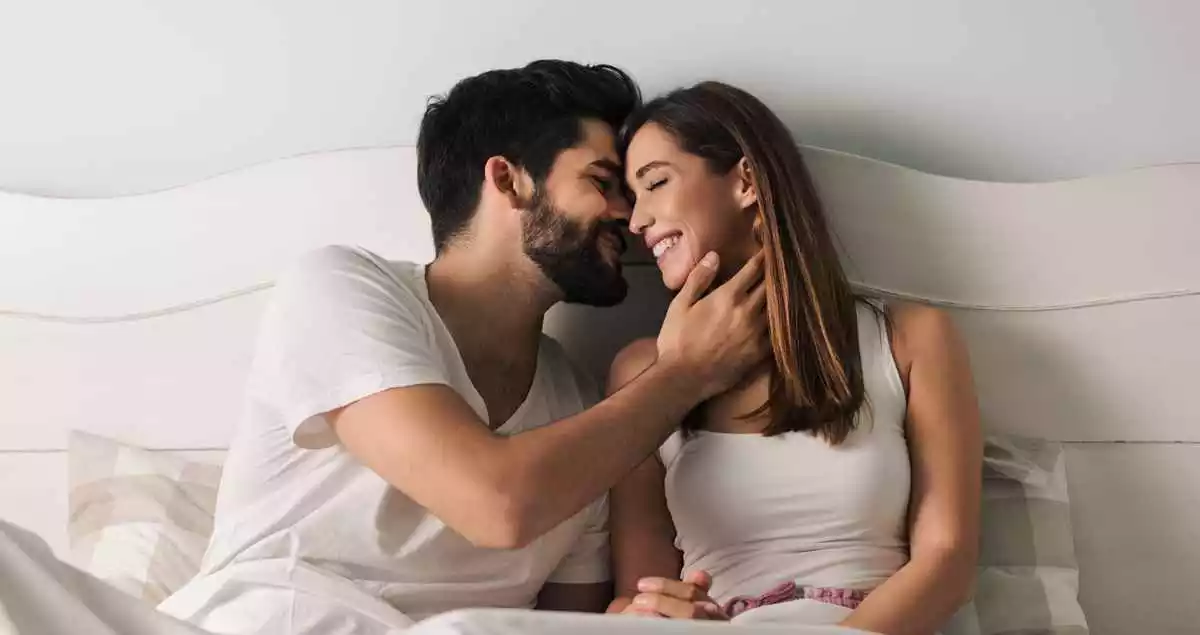 A man and a woman on a bed expressing their love to each other