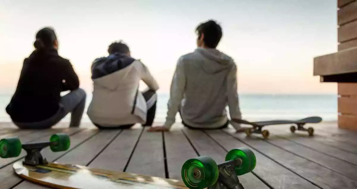 A skateboard with three young boys in the background