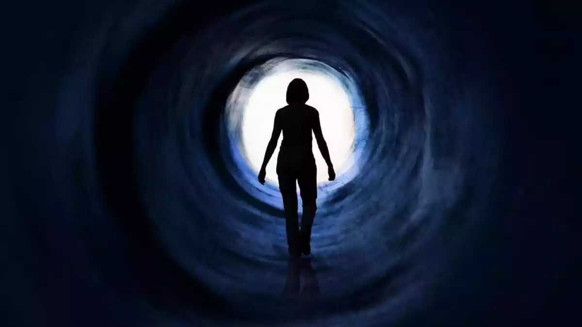 A woman going towards a light tunnel