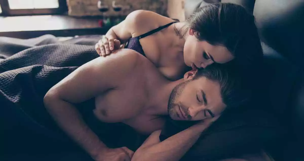 Woman whispering pleasant words to her sleepy man