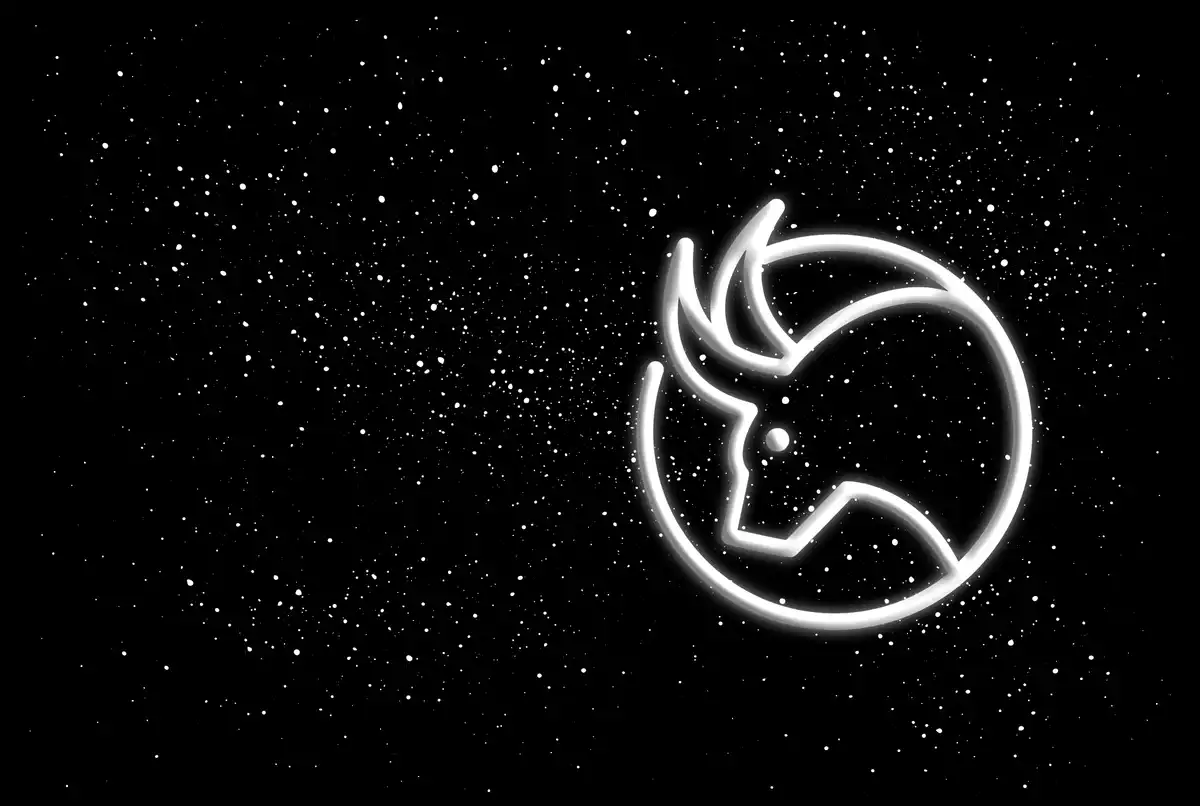 The Taurus sign in white on a black starred background
