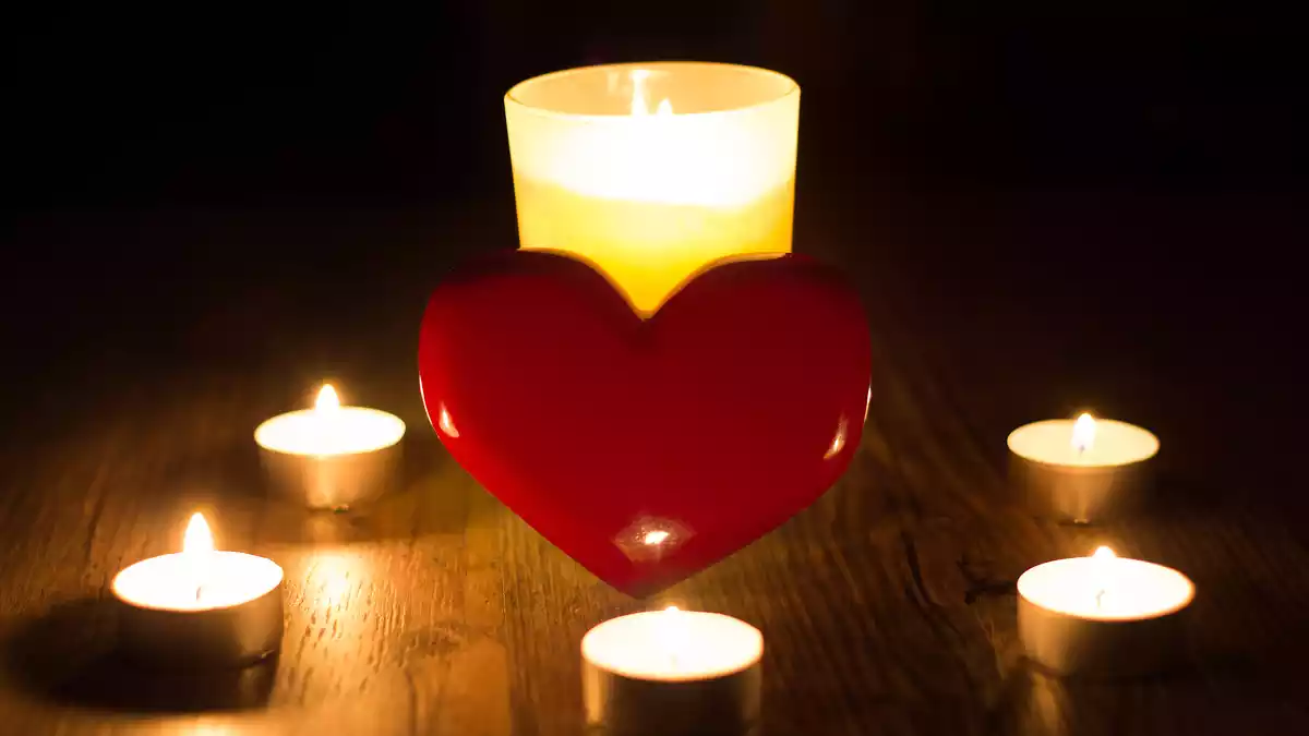 A read heart surrounded by candles