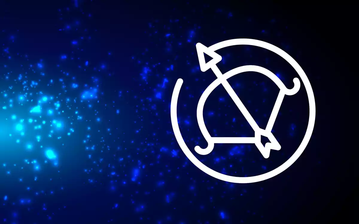 The Sagittarius sign in white on a blue background with some lights