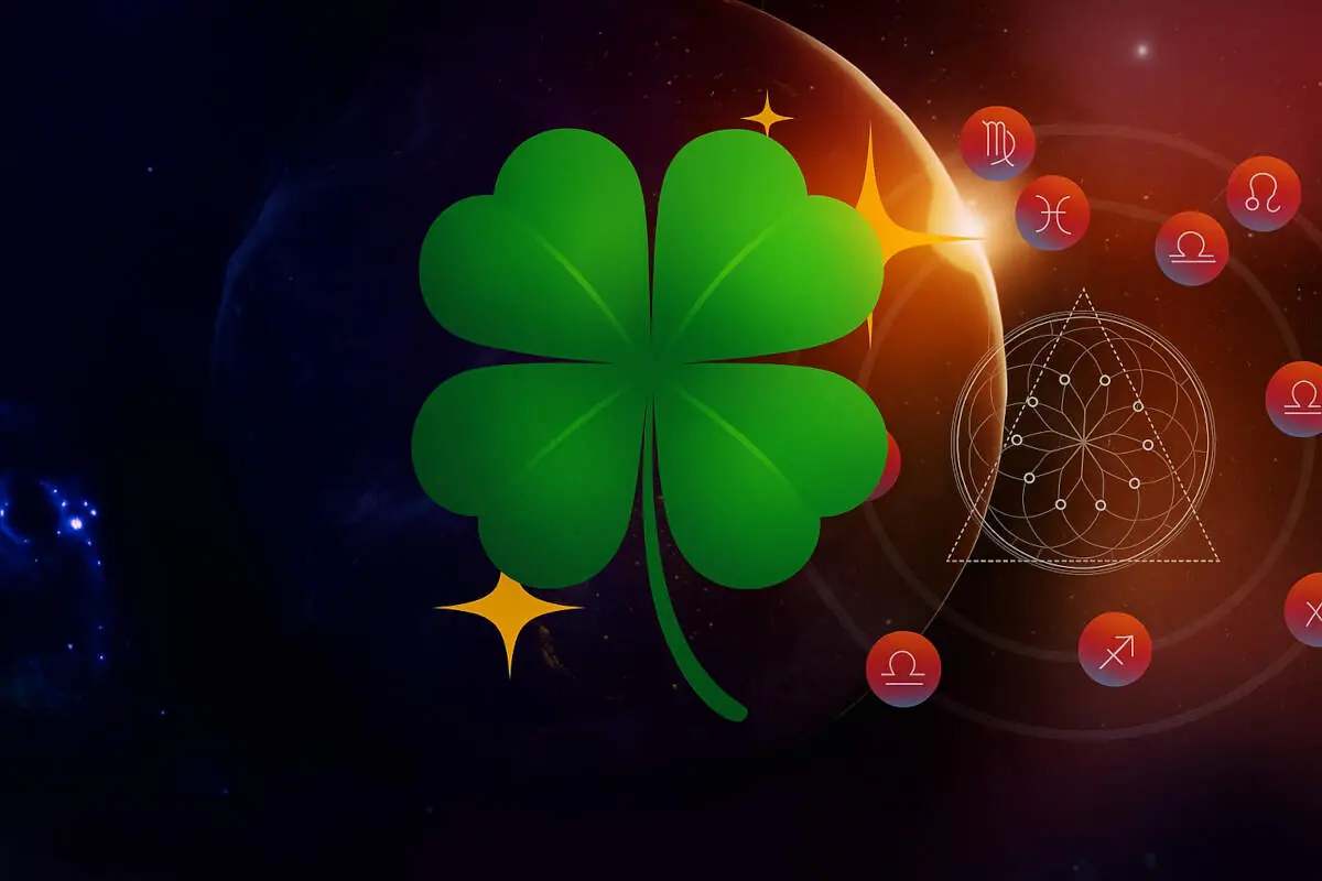 Green four-leaf clover on a space background with zodiac symbols and esoteric figures